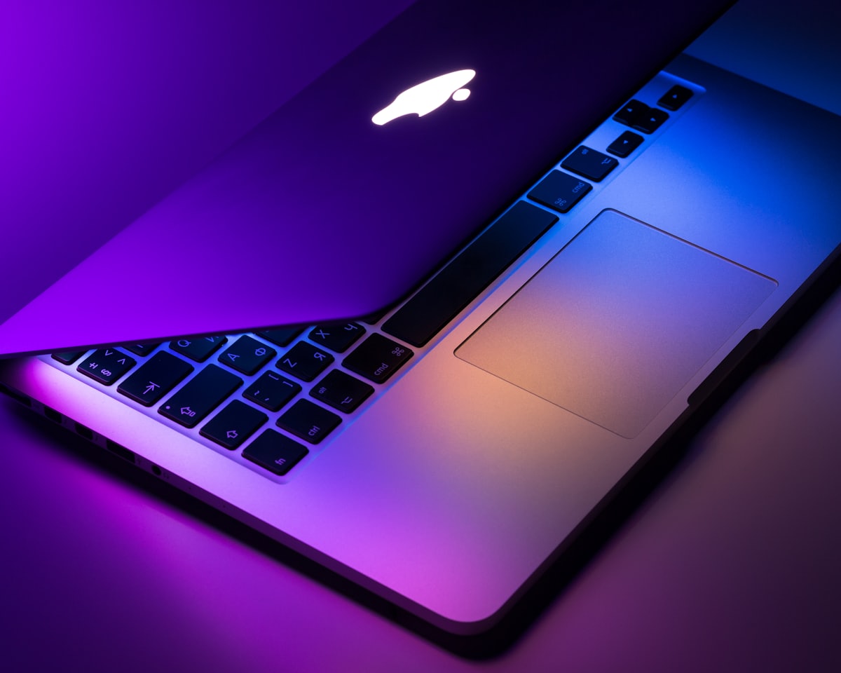 Laptop dalam pencahayaan ungu yang melambangkan keamanan digital